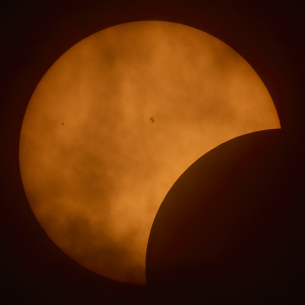 Clouds in front of sun during partial eclipse